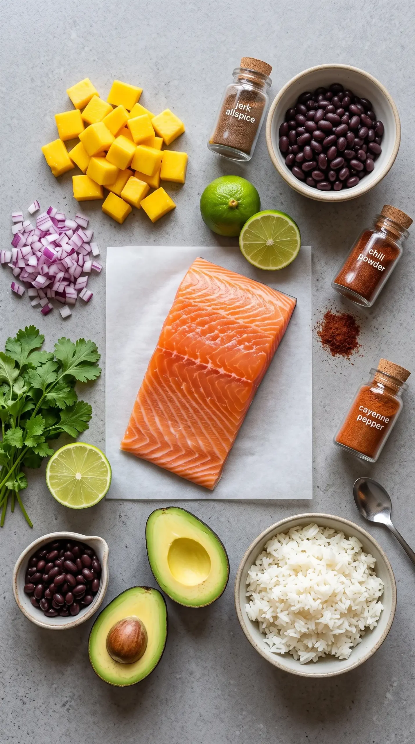 Ingredients for jerk salmon bowl with salmon, mango, cilantro, lime, rice, and spices