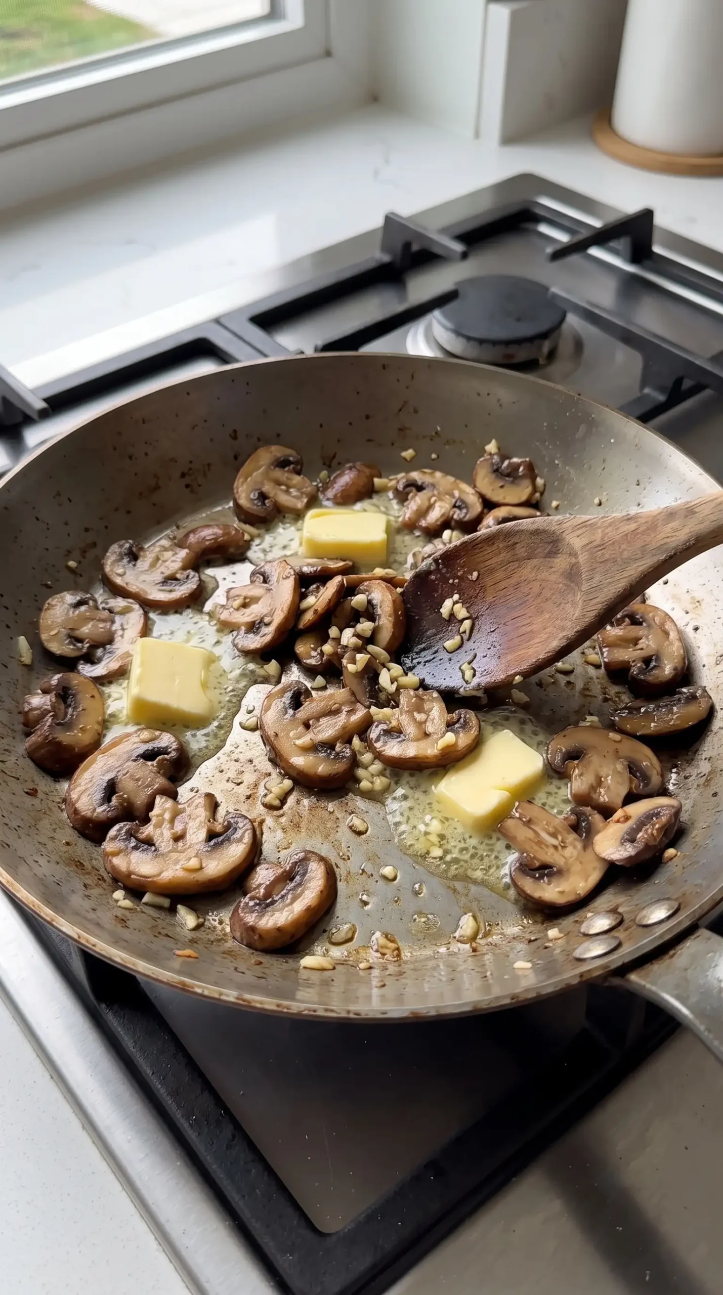 Sautéed mushrooms, garlic, and butter cooking in a pan