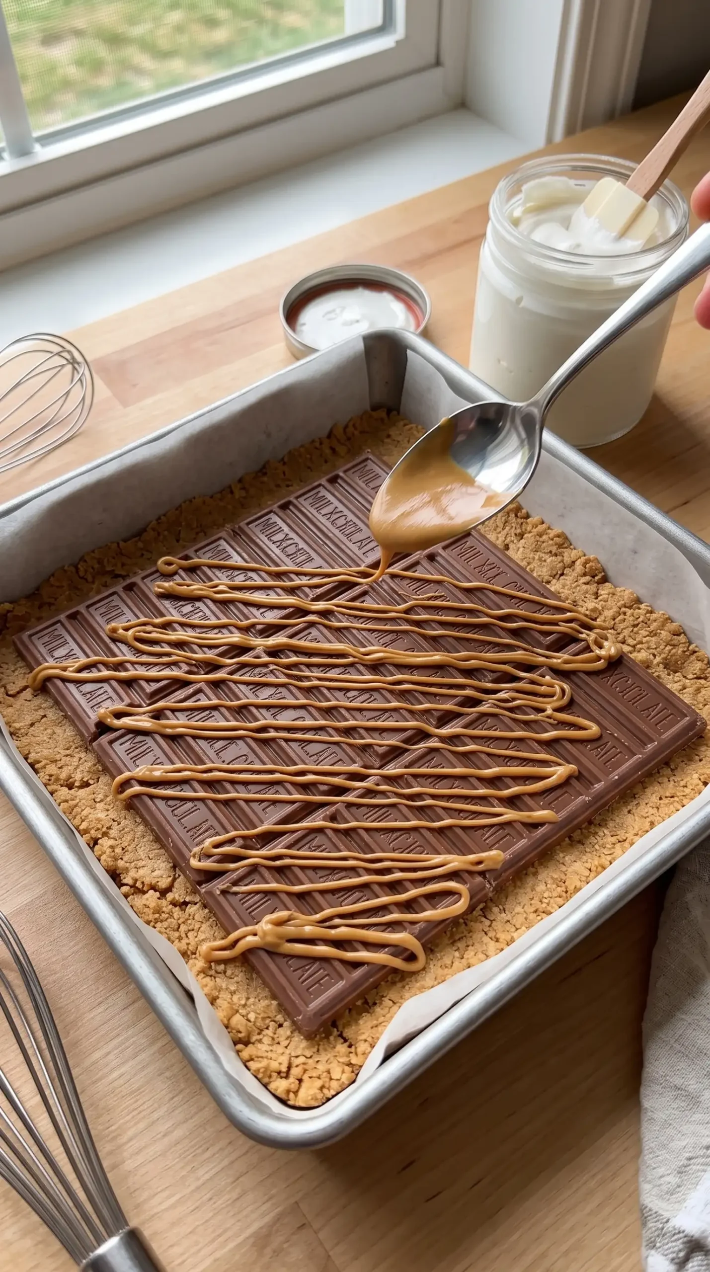 Layering graham cracker dough with chocolate, peanut butter, and marshmallow cream in a baking pan